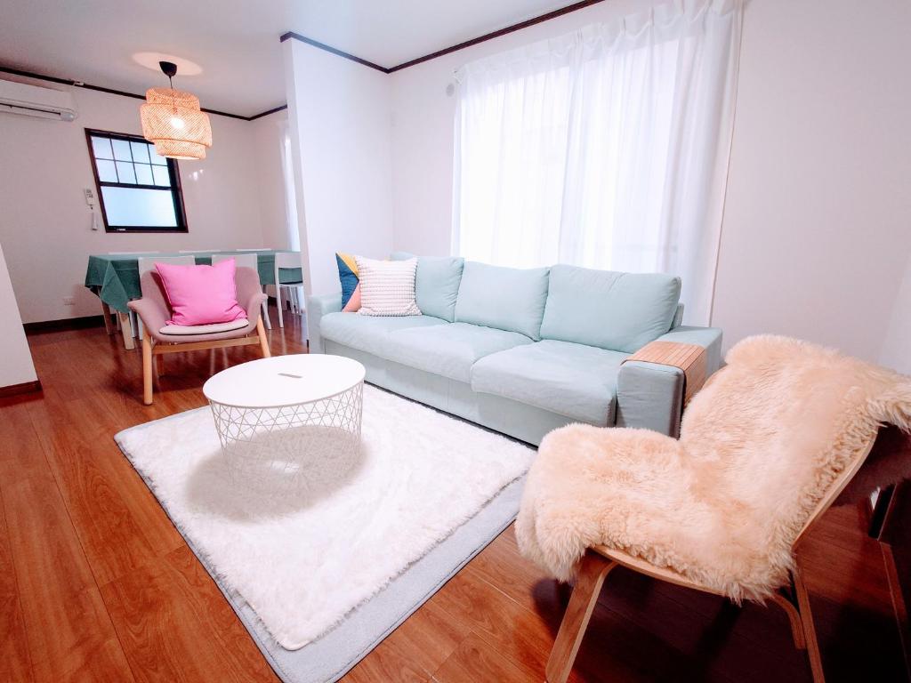 a living room with a blue couch and chairs at Chiba Gateway House in Chiba