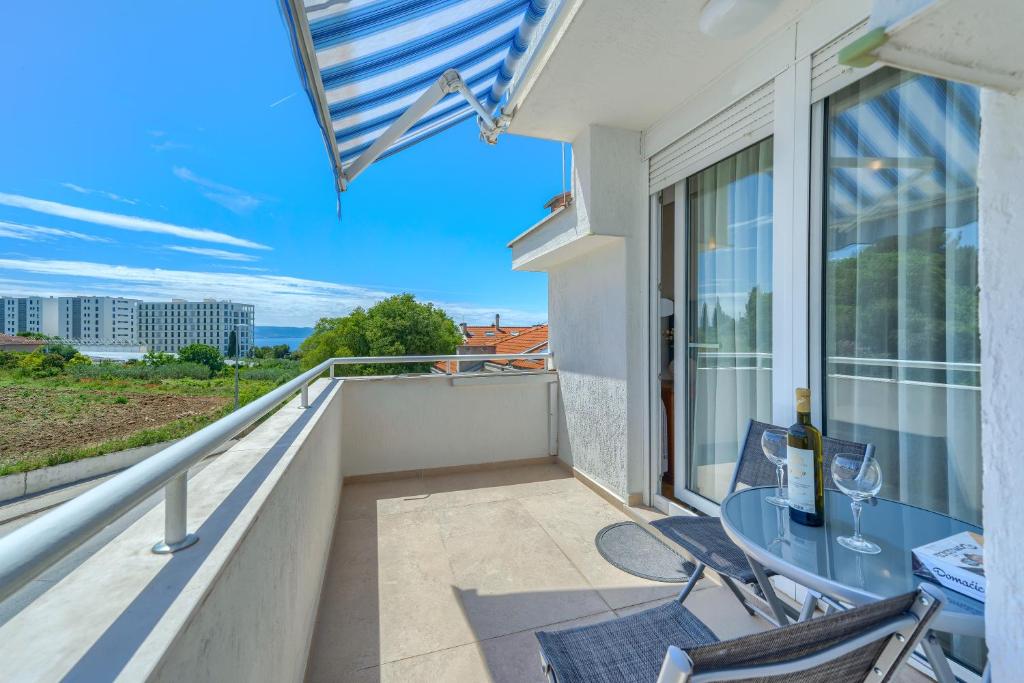 een balkon met een glazen tafel en stoelen bij Apartments Eternity in Split