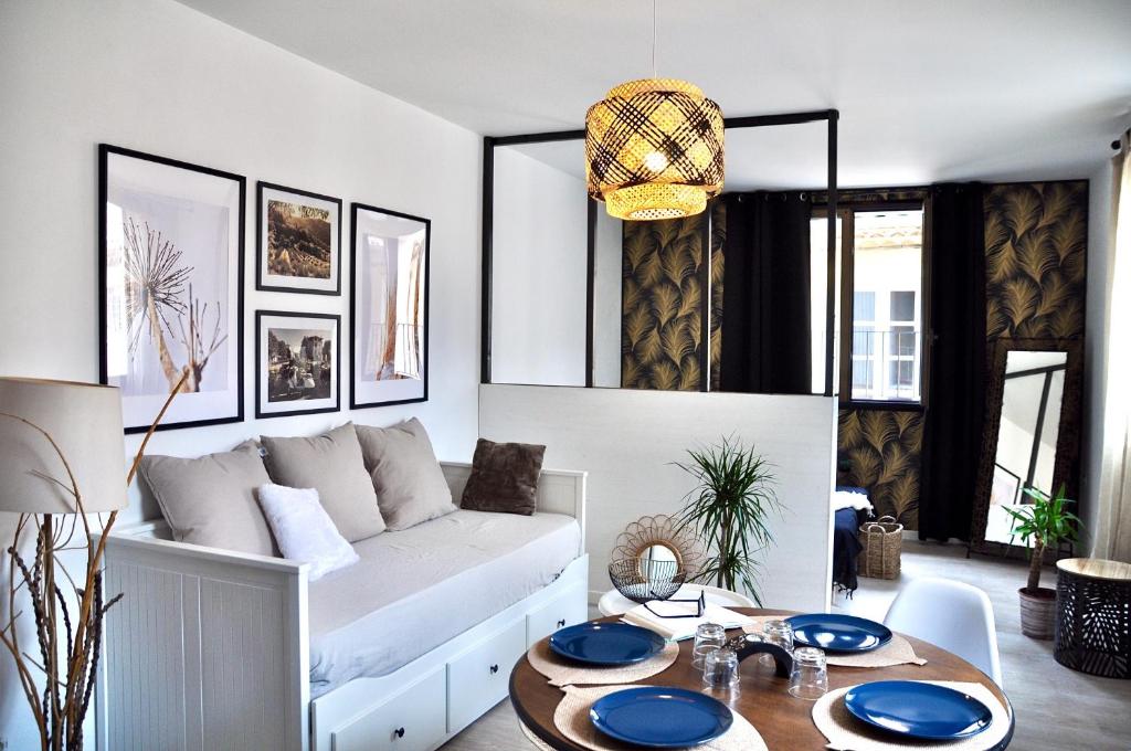 un salon avec un canapé blanc et une table dans l'établissement Ma pause en Provence, à LʼIsle-sur-la-Sorgue