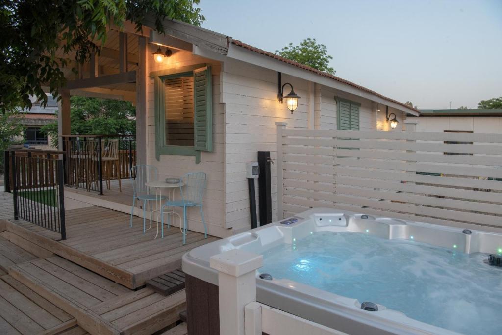 a hot tub on a deck next to a house at הבקתה של רינת in Me‘ona