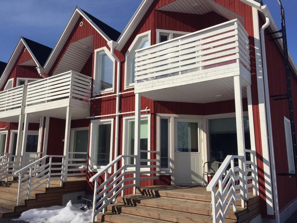 een rood-wit huis met een houten terras bij Rauha Marina 5 in Imatra