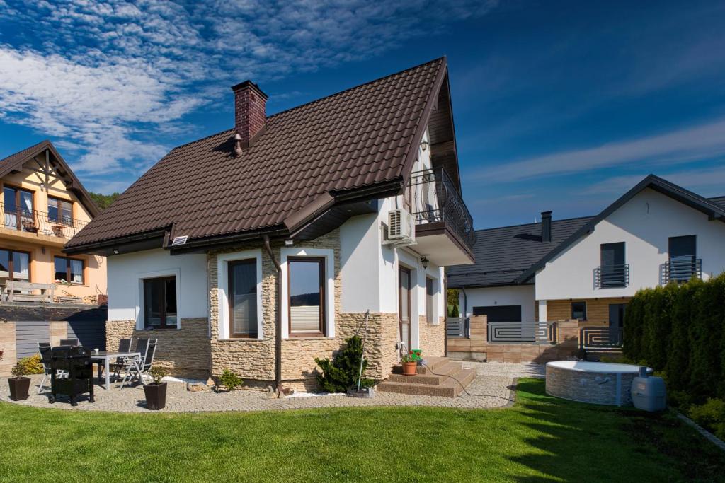 a white house with a brown roof at Wichrowe Zacisze 2 in Krynica Zdrój