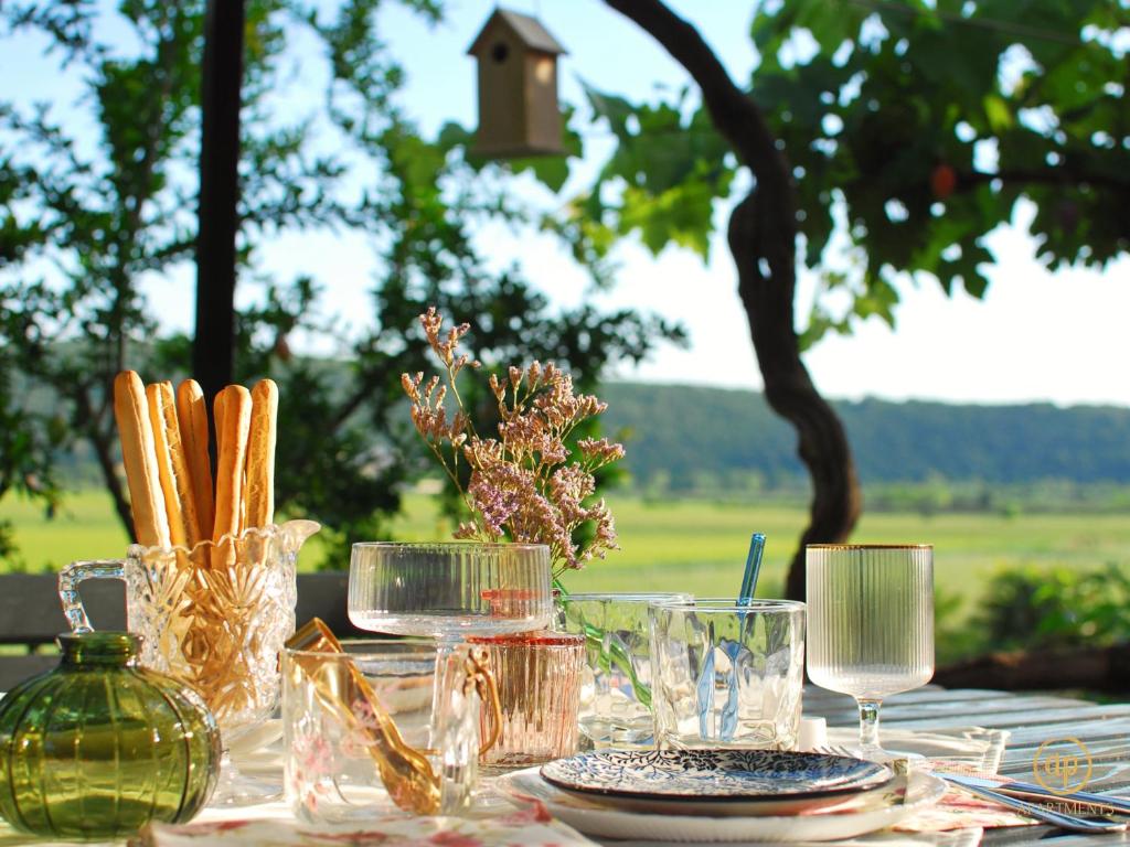 a table with glasses and plates and a bird house at Apartment Irene in Sečovlje