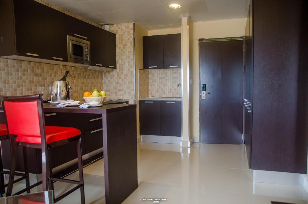 a kitchen with black cabinets and a red chair at Hotel Inter Tete in Tete