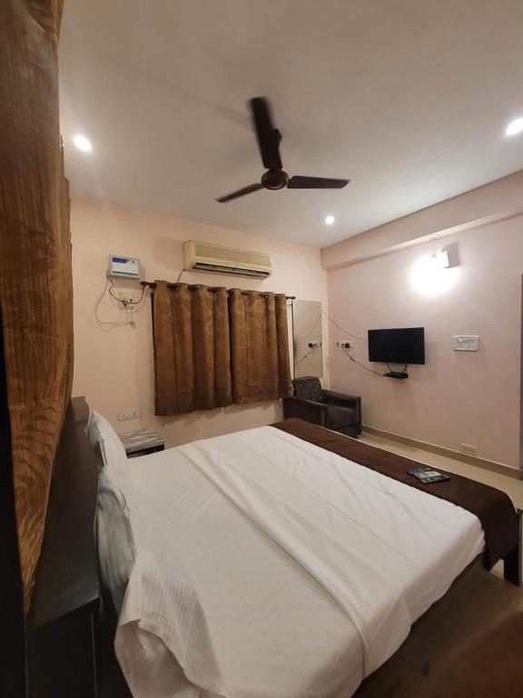 a bedroom with a bed with a ceiling fan at Five stones By Earth Hotel Vadapalani in Chennai