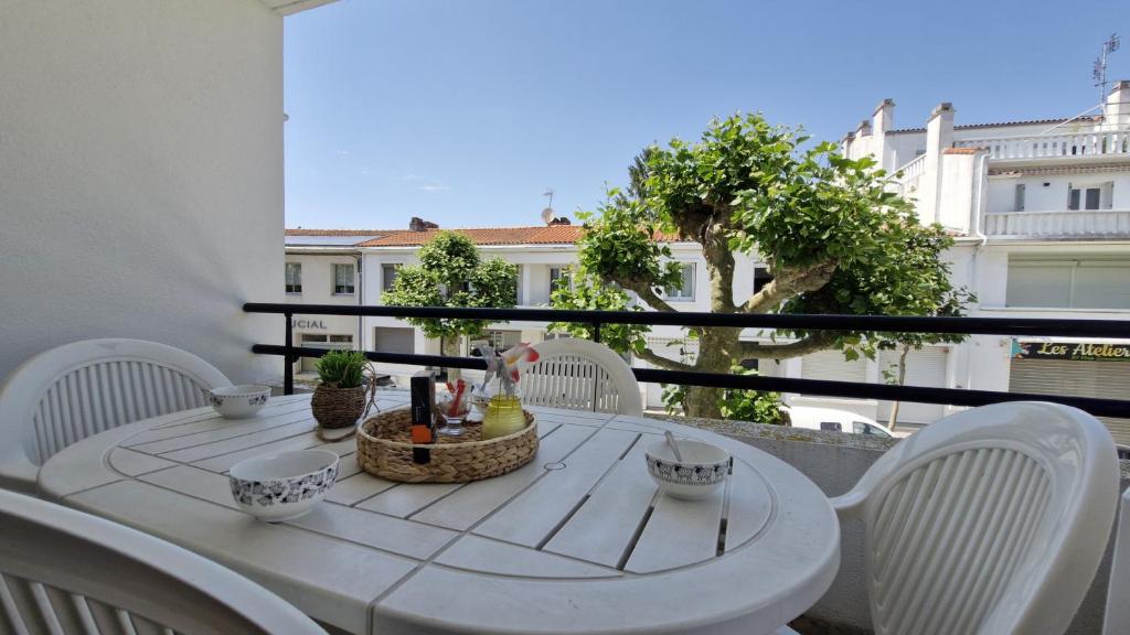 une table blanche et des chaises sur un balcon dans l'établissement Royan - APPARTEMENT avec EMPLACEMENT IDEAL - terrasse - garage privatif, à Royan