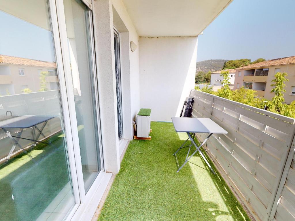 balcone con prato verde, tavolo e sedie di Appartement de charme avec piscine, terrasse, parking, clim et Wi-Fi – à 10 min des plages - FR-1-785-2 a Frontignan