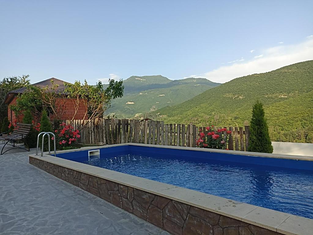 a swimming pool with a fence and mountains in the background at Green Garden in Ijevan