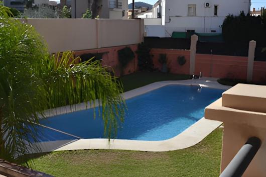 a large blue swimming pool in a yard at Apartamento Mirasol con parking privado in Fuengirola