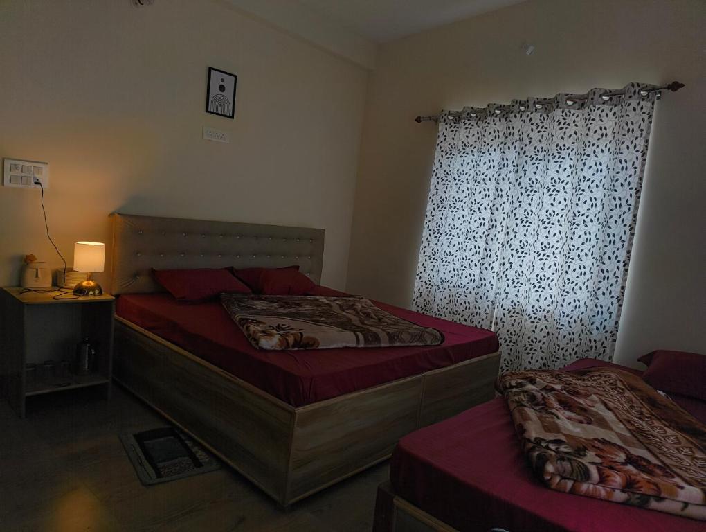 a bedroom with two beds and a window at Ganga Kinaare in Uttarkāshi