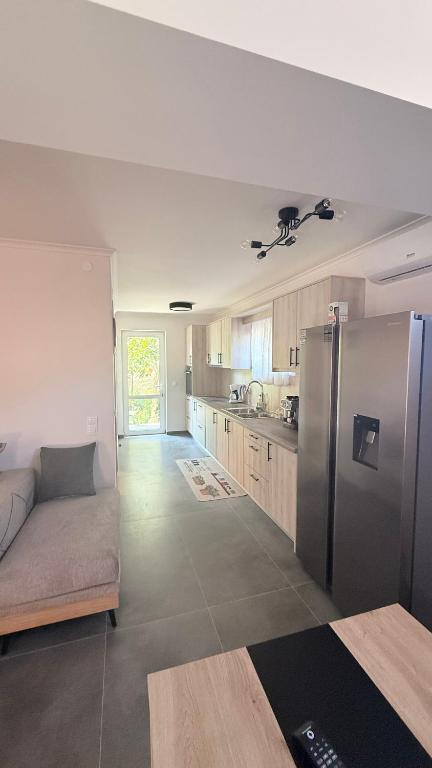 a kitchen with a couch and a stainless steel refrigerator at Harmony Home in Kouspádes