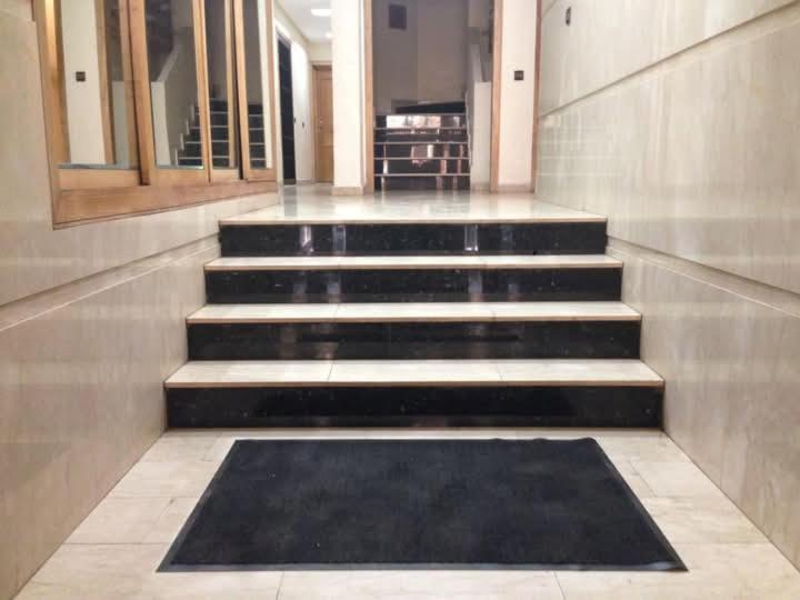 Un conjunto de escaleras en un edificio con una alfombra negra. en Résidence journalière chic Casablanca, en Casablanca