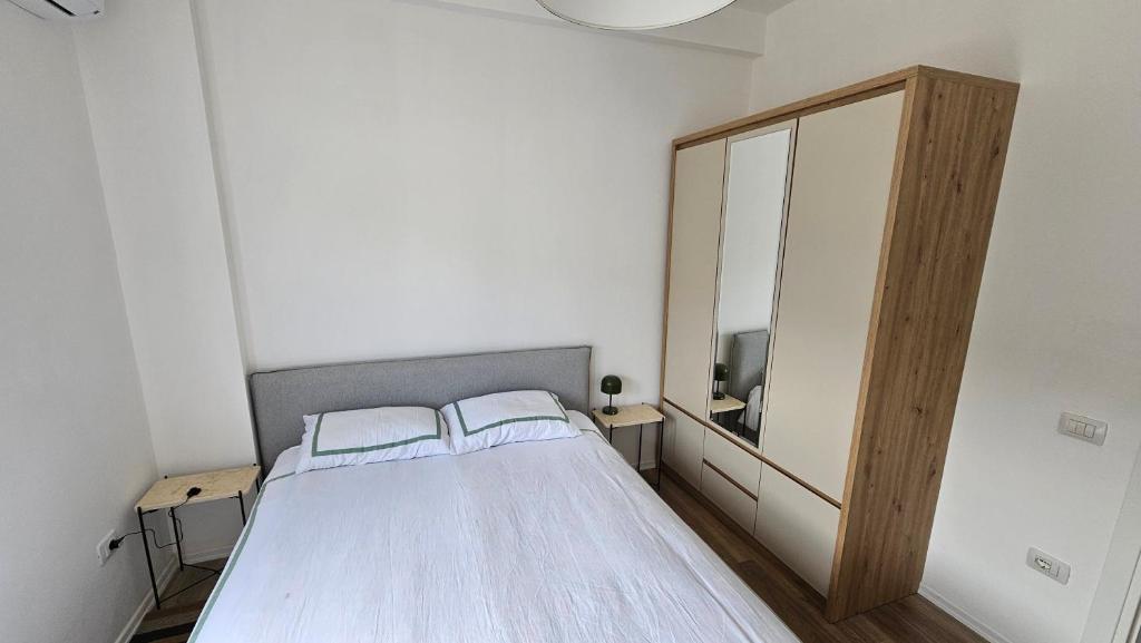 a bedroom with a bed and a large mirror at Modern apartment with sea views in Vlorë