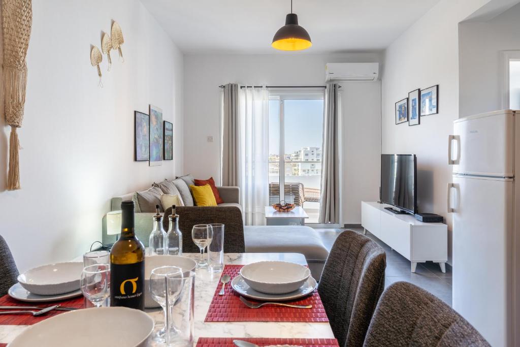 a kitchen and living room with a table and a refrigerator at Olympus 2-Bedroom Apartment in Larnaca