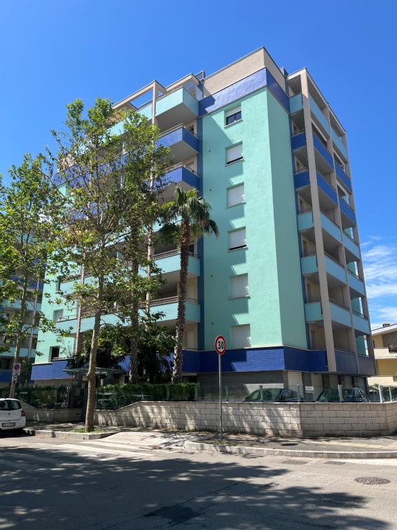 un condominio blu con un albero di fronte di Aquarius a Montesilvano Marina