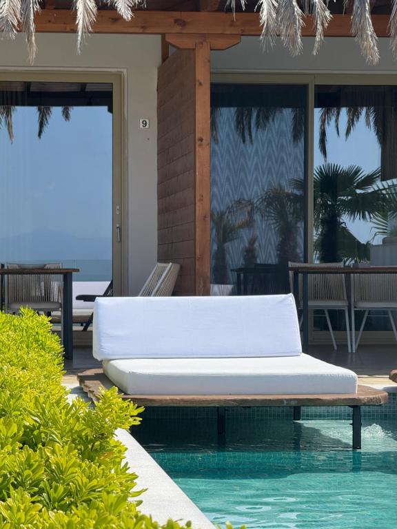 a white bed sitting next to a swimming pool at SANIMAR By Mono Alex in Kassandra