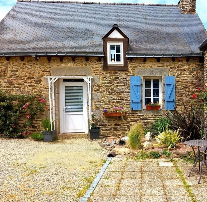 une maison en briques avec une porte blanche et des volets bleus dans l'&eacute;tablissement Cottage Lavandes et Cottages Roses, &agrave; Cr&eacute;din