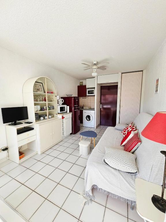 Il comprend un salon doté de carrelage blanc. dans l'établissement ARGELES PLAGE STUDIO PISCINE PARK PRIVATIF dans RES SECURISEE, à Argelès-sur-Mer