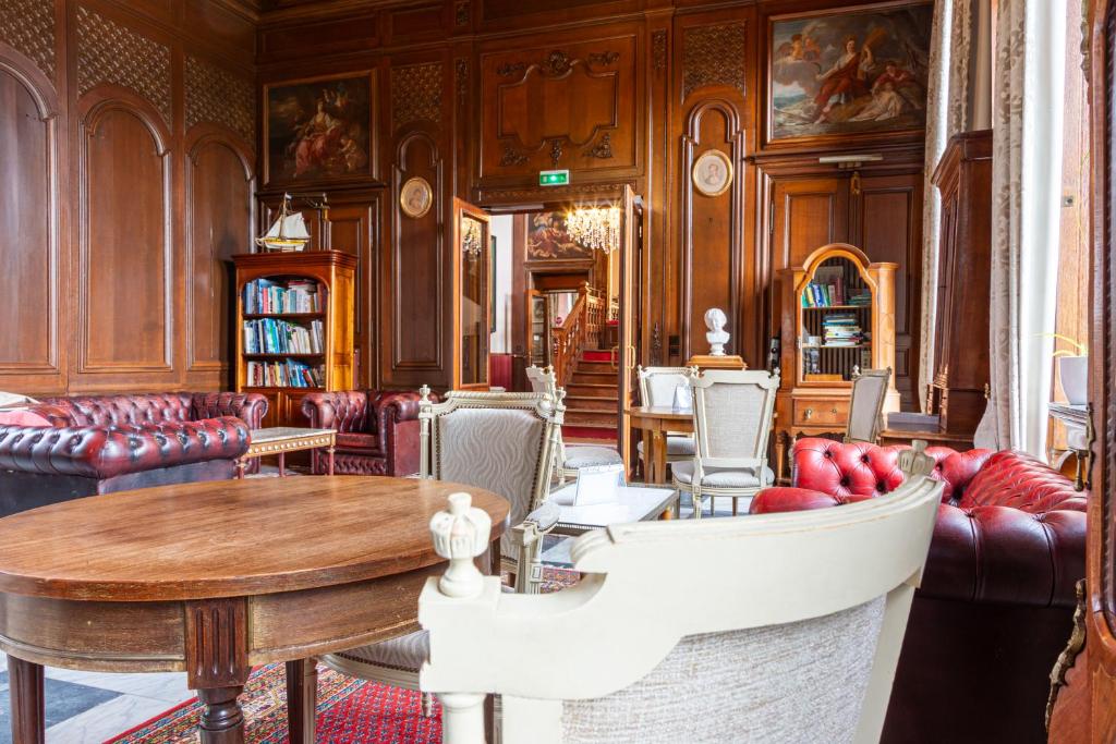 een woonkamer met een tafel en stoelen bij Château Hôtel Du Colombier in Saint-Malo