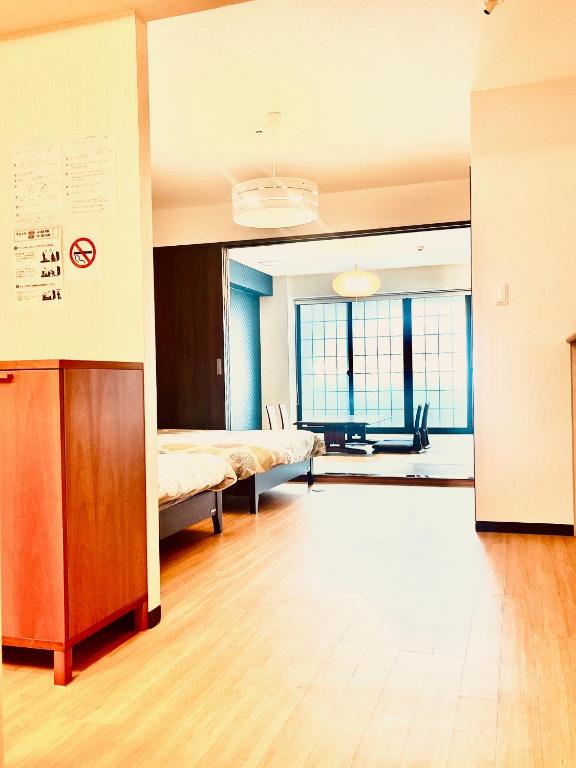 an empty room with a bed and a table at guest house Sakura in Osaka