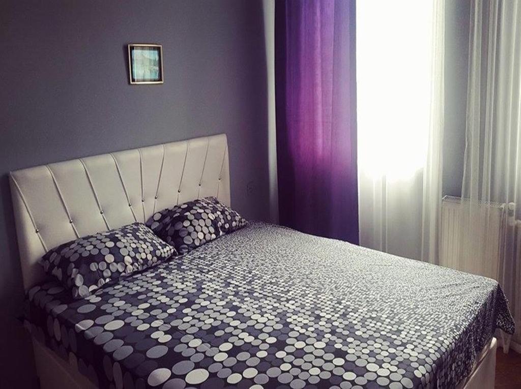 1 dormitorio con cama con edredón y ventana en Eka Guest House en Batumi