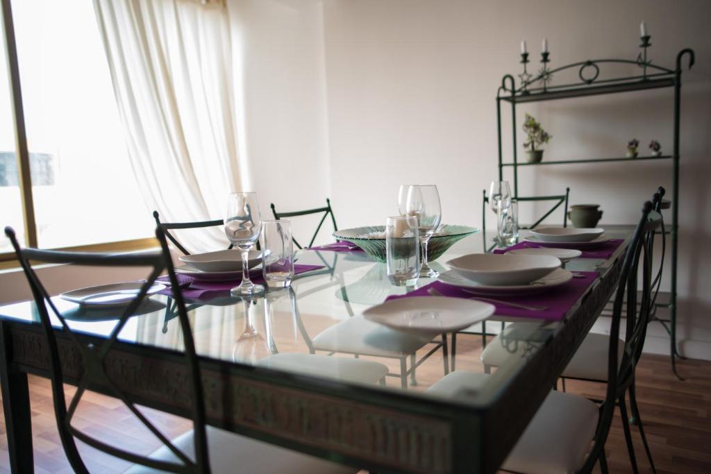 a glass table with chairs and wine glasses on it at San Salvatore in St. Julianʼs