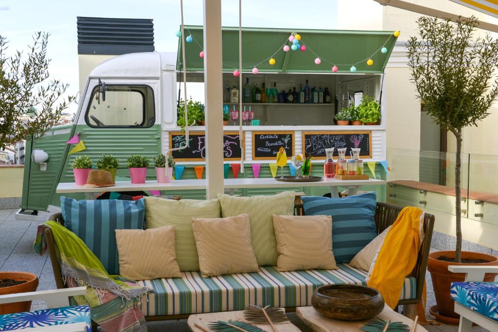 un patio con sofá y un camión de comida en Vincci The Mint, en Madrid
