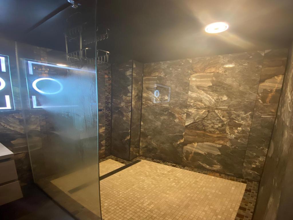 a shower in a room with a stone wall at Majestic Wellness Center in Brussels