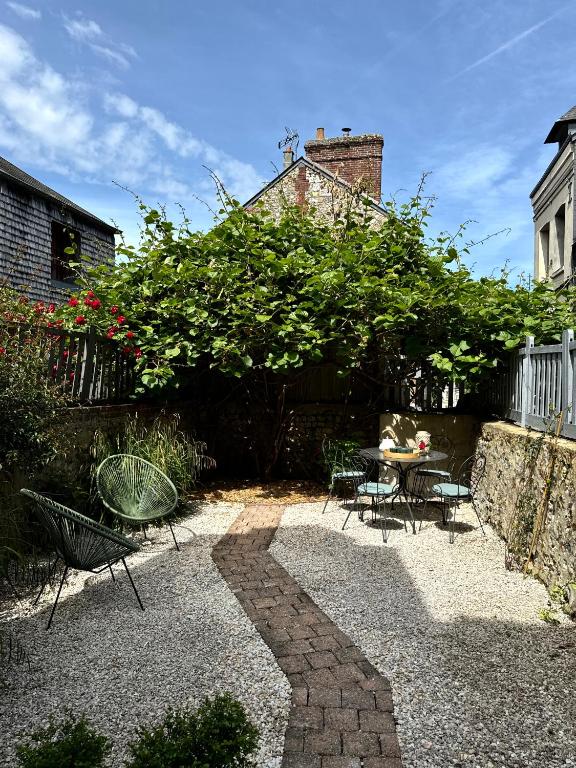 d'une terrasse avec une table et des chaises dans le jardin. dans l'établissement Le Nid Sainte-Catherine, à Honfleur