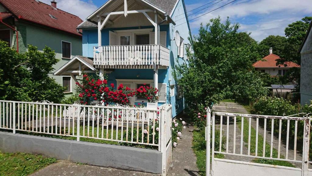 una staccionata bianca davanti a una casa blu con balcone di Apartments in Zalakaros - Thermalbad 20673 a Zalakaros
