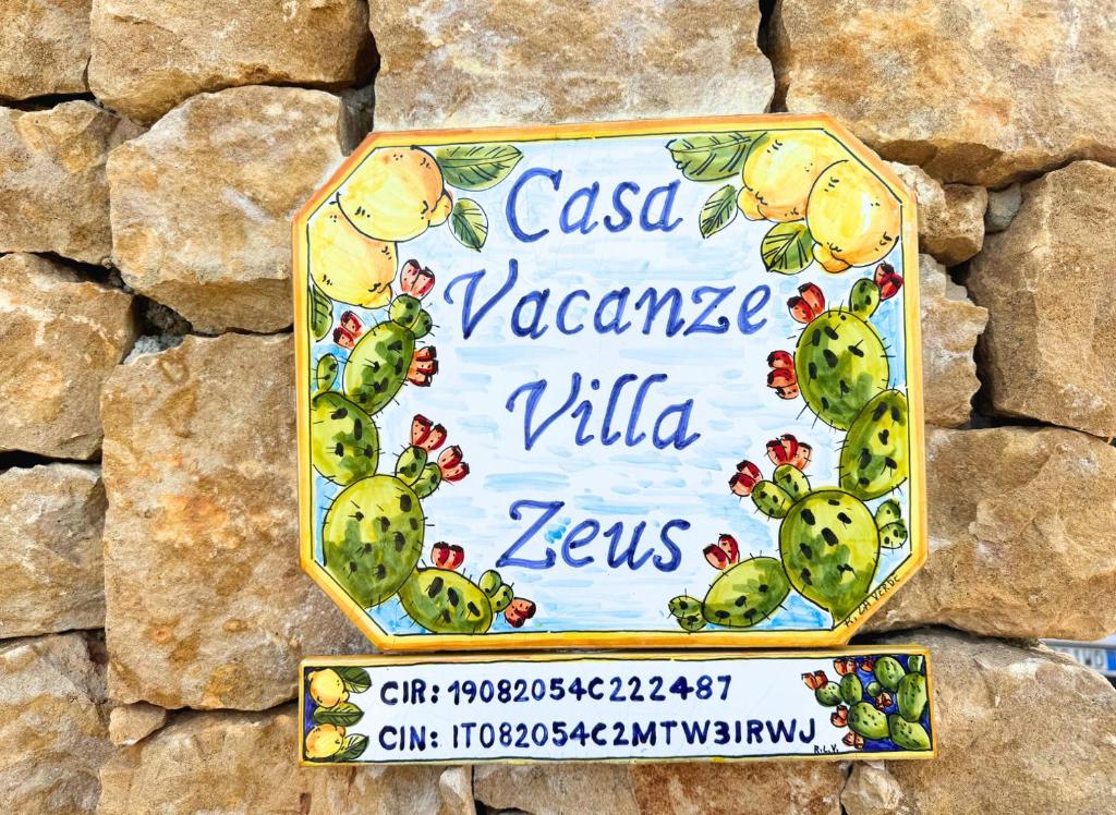 a sign on the side of a stone wall at Case Vacanza Zeus in Trappeto