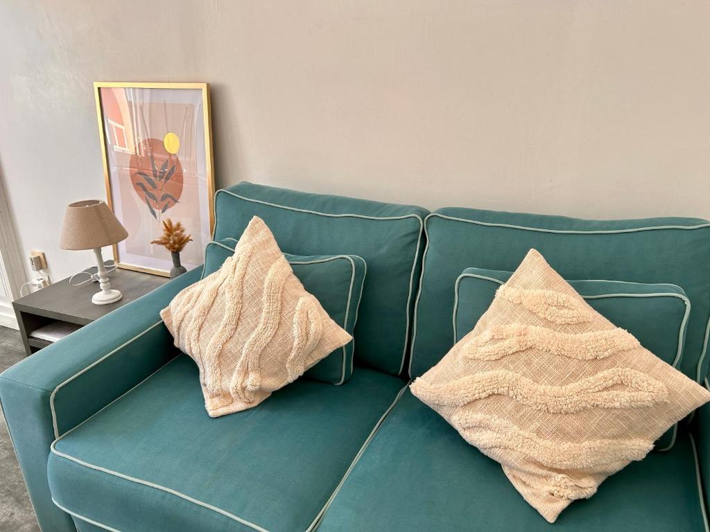 - un canapé bleu avec deux oreillers dans l'établissement 17 Rue du Puits de la Place, à Granville