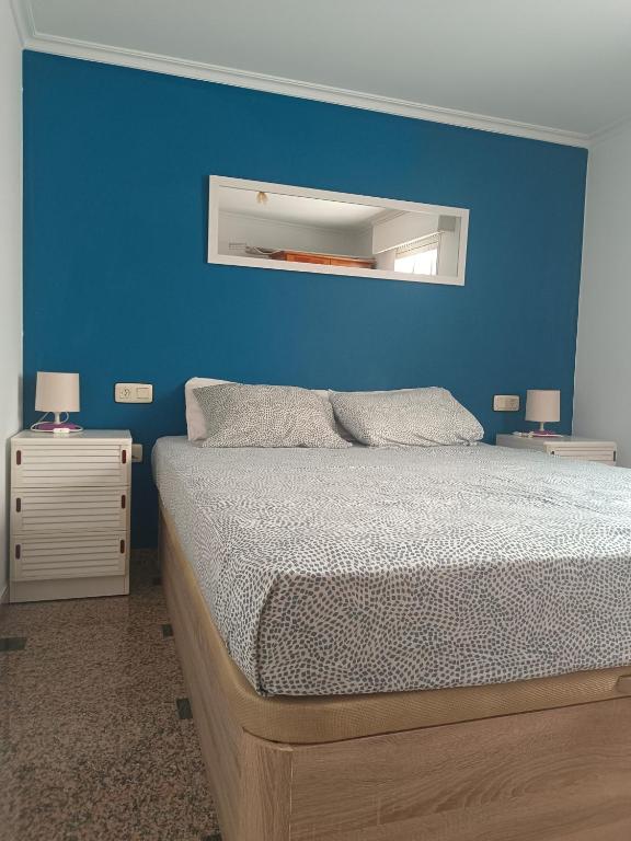 a bedroom with a blue wall and a bed at El apartamento de arriba in Cedeira