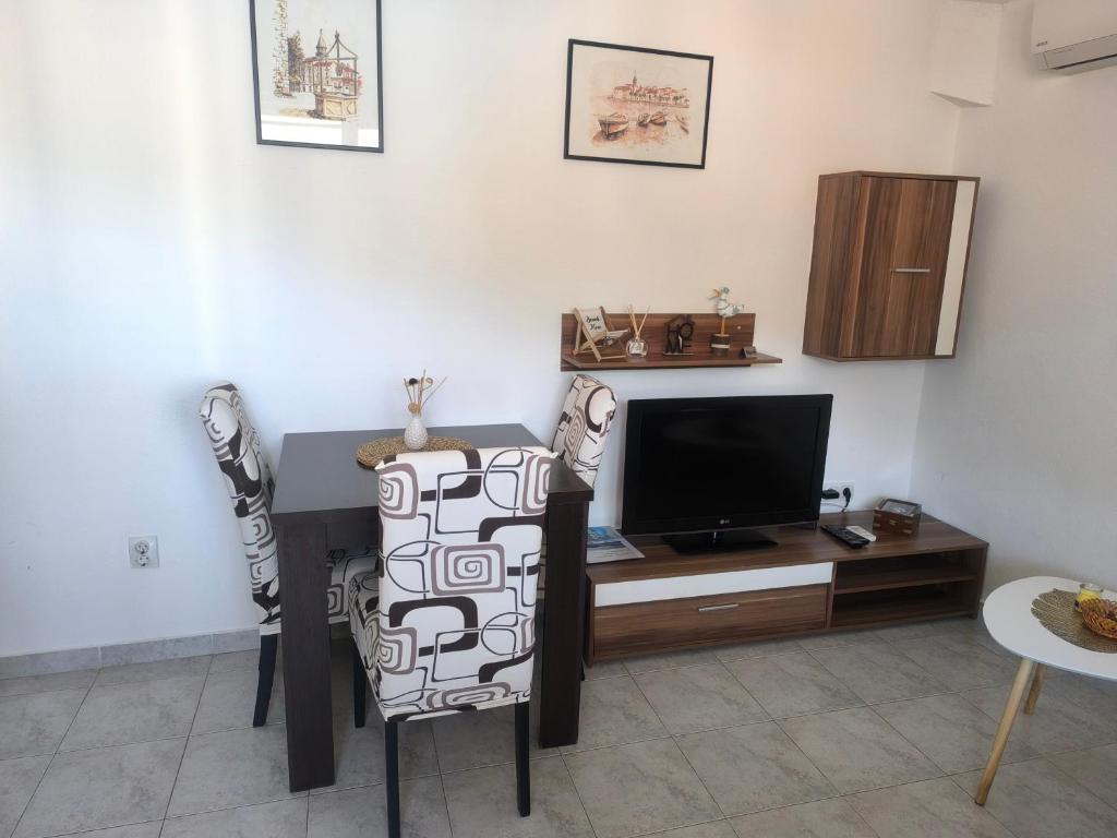 un soggiorno con scrivania e TV di Petrovic apartmani a Tivat