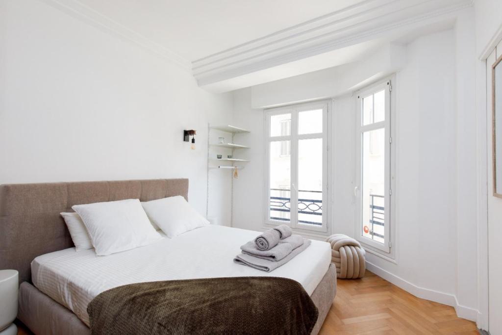 - une chambre blanche avec un grand lit et des fenêtres dans l'établissement Stylish renovated studio near the Palais, à Cannes