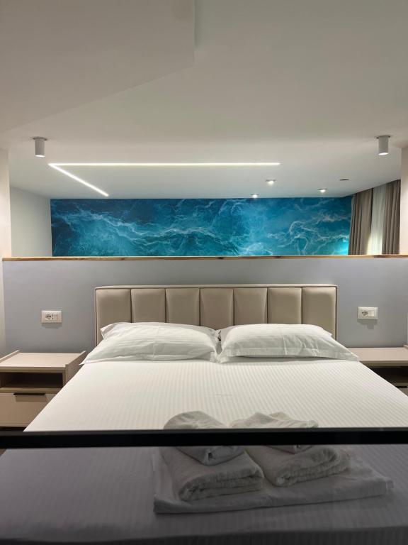 une chambre avec un lit avec un tableau sur le mur dans l'établissement Duplex City, à Durrës
