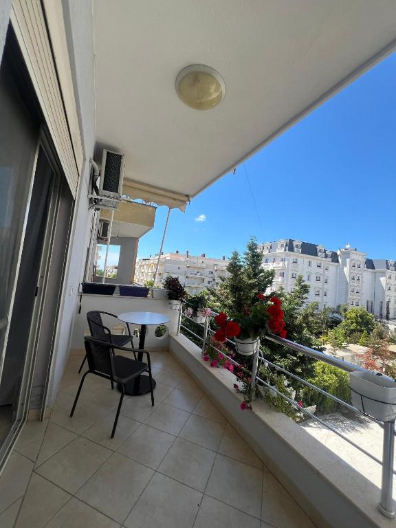 a balcony with a table and chairs and a view of a city at Flower Apartment Golem in Golem