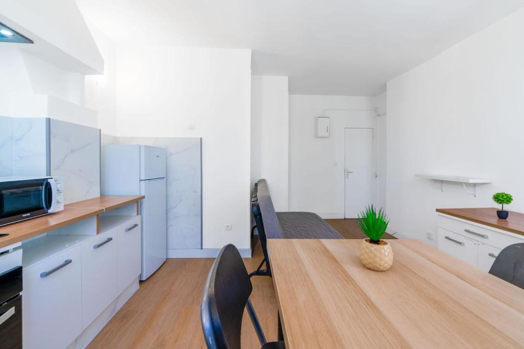 une cuisine avec une table et des chaises dans une pièce dans l'établissement Joli appartement 2 pièces proche gare St Charles, à Marseille