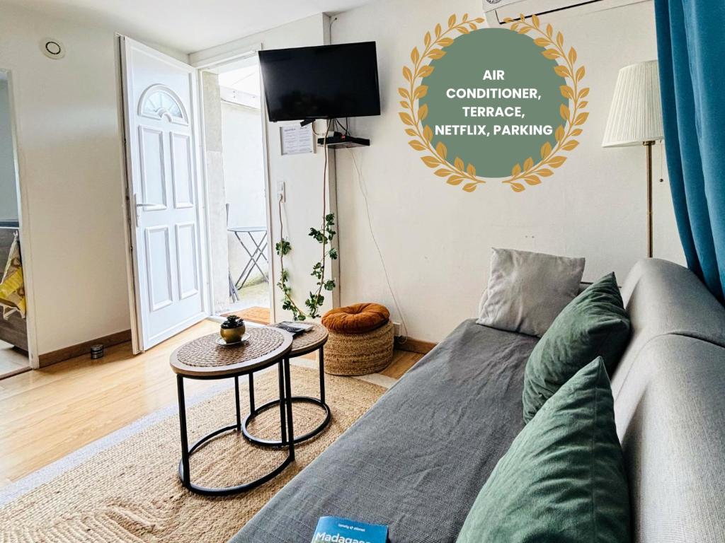 un salon avec un canapé et une table dans l'établissement Appartement climatisé avec terrasse - Goupama Stadium, Eurexpo, LDLC Arena, La Soie, à Vaulx-en-Velin