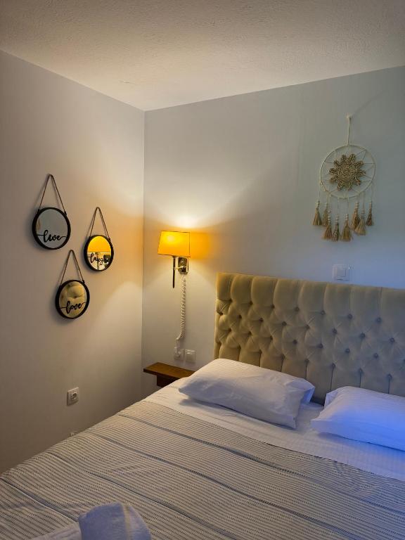 a bedroom with a large bed and a clock on the wall at Beko Corfu house in Gouvia