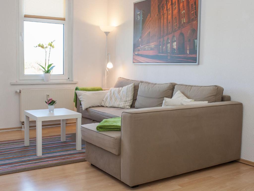 ein Wohnzimmer mit einem Sofa und einem Tisch in der Unterkunft Ferienwohnung Leipzig Nord in Leipzig