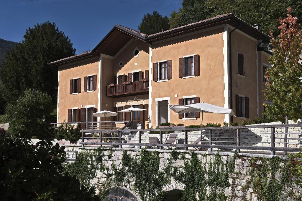 a building with tables and umbrellas in front of it at La Villa degli Orti in Borgo