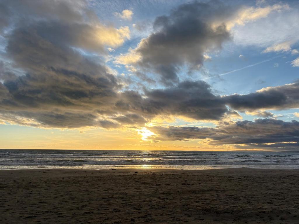 - une plage avec un ciel nuageux et l'océan dans l'établissement Appartement piscine plage golf, à La Grande Motte