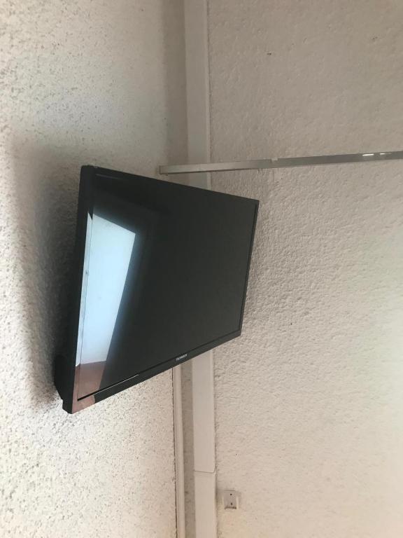 un téléviseur à écran plat accroché au mur dans l'établissement RESIDENCE SOGNU DI MARE PLAGE Marine di Bravone, à Linguizzetta