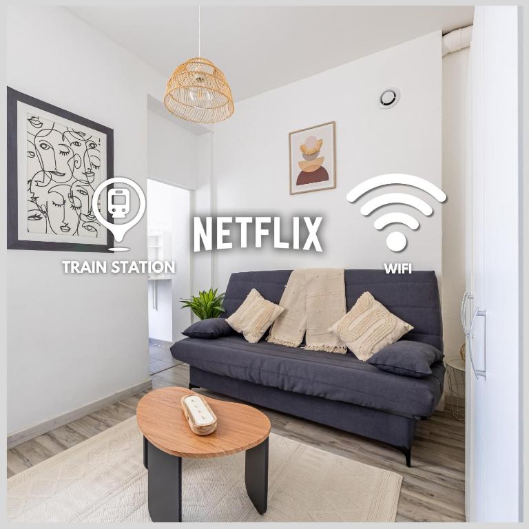 un salon avec un canapé bleu et une table dans l'établissement Le Skandi Centre ville, à Reims