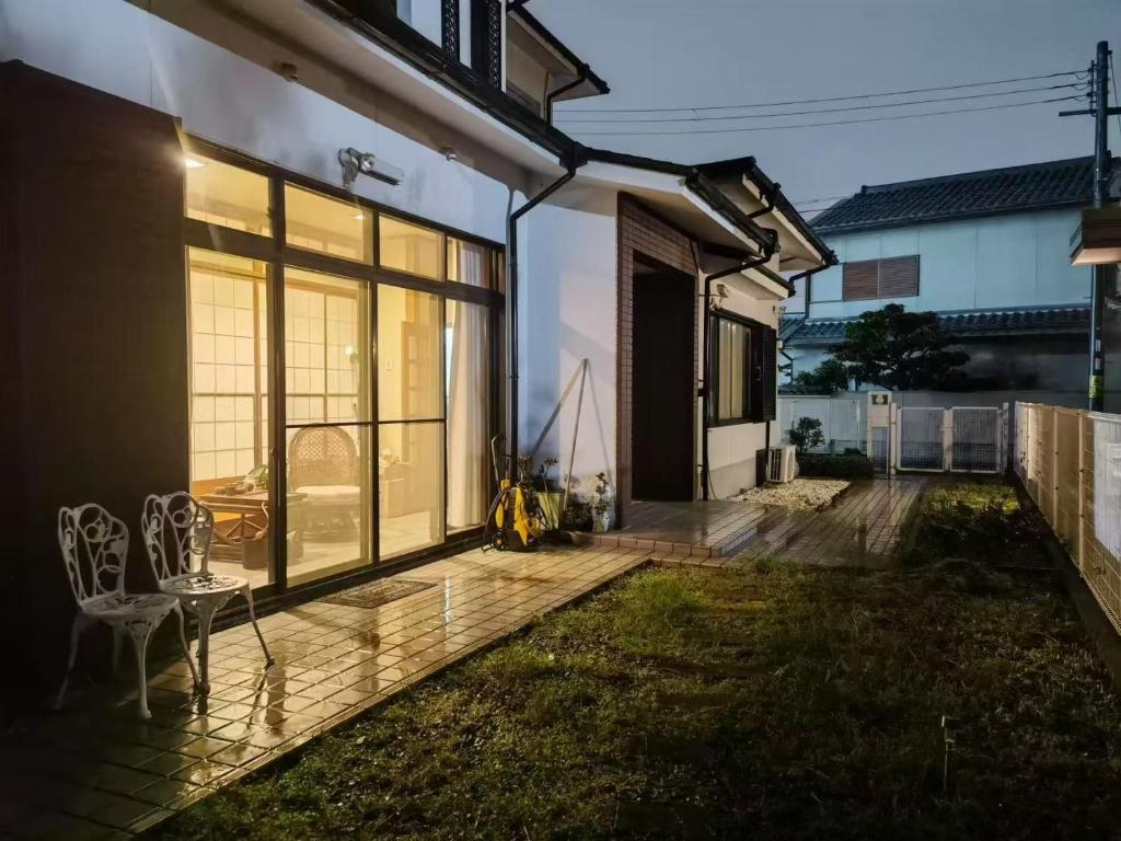a patio with a table and chairs next to a house at 海の風 in Wakayama