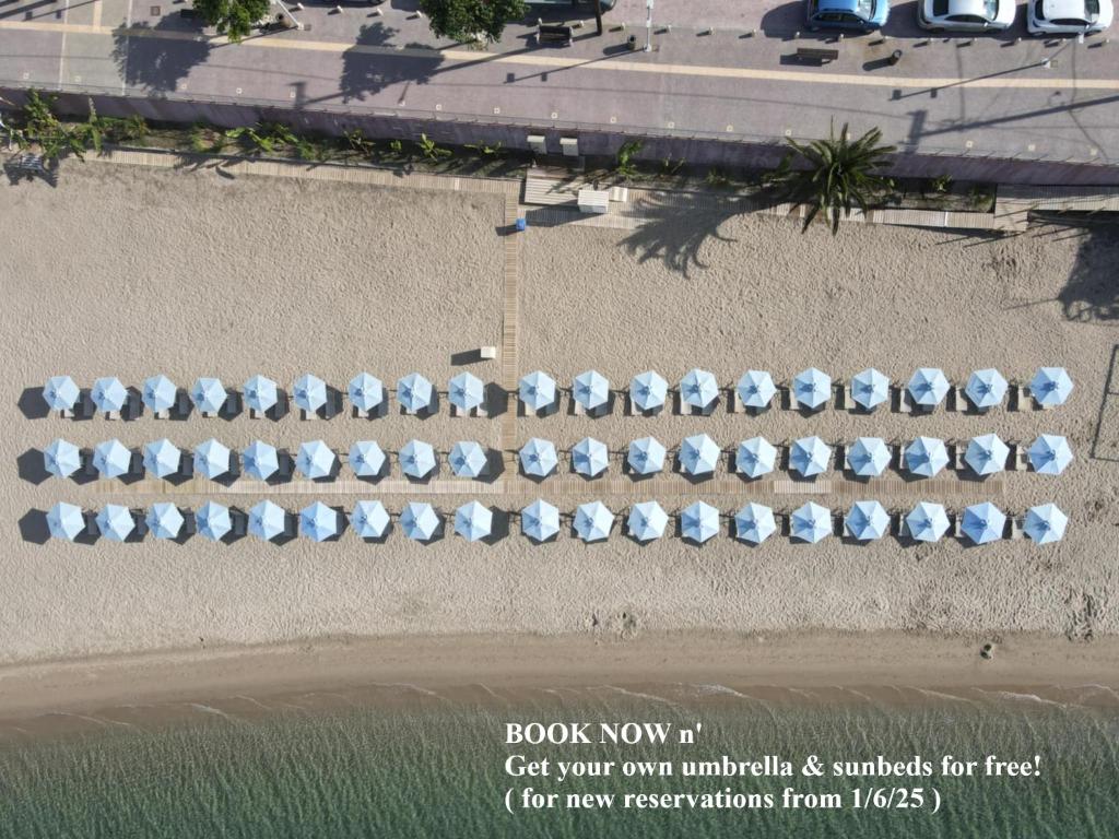 an overhead view of a row of umbrellas on the beach at Aegean Blue Beach Hotel in Nea Kalikratia