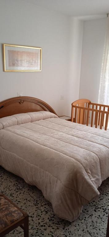 a large bed in a bedroom with two chairs at Apartamento Moraledas in Lanjarón