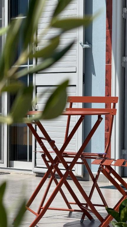 a red chair sitting in front of a door at Vila Bedro in Sarandë