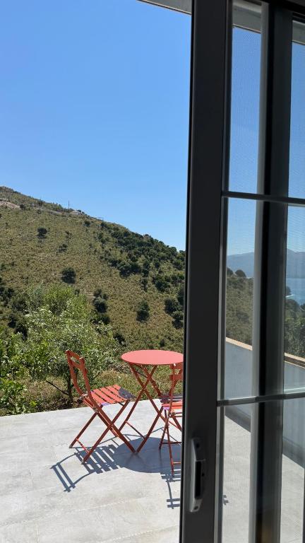 a table and chairs sitting on a patio with a window at Vila Bedro in Sarandë
